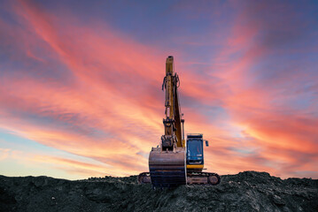 Wall Mural - Excavator on sunset background. Open-pit mining. Backhoe dig ground in quarry. Heavy construction equipment on excavation on construction site. Excavator on groundwork on dramatic twilight. 