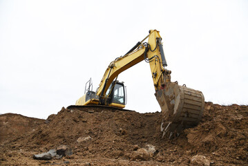 Wall Mural - Yellow tracked excavator isolated on white background. Backhoe loader isolation. Rock breaker machine