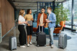 © LIGHTFIELD STUDIOS - Multicultural group of businesspeople in casual attire standing around with luggage in a hotel lobby during a corporate trip.