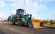 © MaxSafaniuk - Wheel loader with a bucket on the road construction. Construction site with heavy machinery on road construction. Civil engineering. Heavy machinery for loading and unloading works on roadworks.
