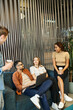 © LIGHTFIELD STUDIOS - A creative startup team of colleagues shares innovative ideas while perched atop a couch in a modern coworking space.