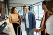 © LIGHTFIELD STUDIOS - Multicultural colleagues in casual clothes standing in a circle, interacting and bonding in a hotel lobby during a corporate trip.