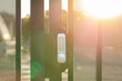 © Austockphoto - Digital smart lock on gate of fence around worksite with sun flare haze