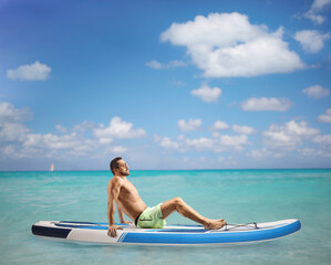 Sticker - Young man sunbathing on a SUP