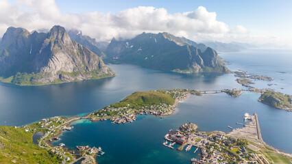 Wall Mural - An aerial view of Reine, a picturesque village in the Lofoten Islands of Norway, showcasing the dramatic mountains, clear waters, and charming harbor. Reinebringen, Lofoten, Norway