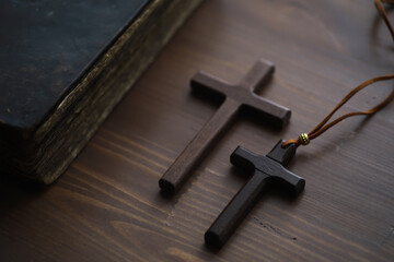 Vintage Wooden Crosses and Ancient Bible on Wooden Table, Symbolizing Faith and Religion