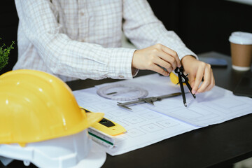 Wall Mural - Concept architects or engineer holding pen pointing equipment architects on the desk with a blueprint in the office.