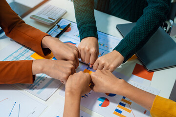 Close up view from top businesspeople putting hands together above the table express unity and support. Symbol gesture of friendship togetherness and like-minded people concept.