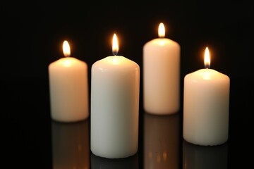 Wall Mural - Many burning candles on mirror surface against black background