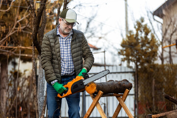 Man cutting wood with saw, dust and movements. Chainsaw.