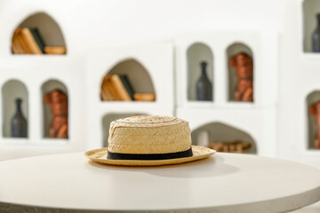 Summer hat on wooden table and white home interior with natural light. 