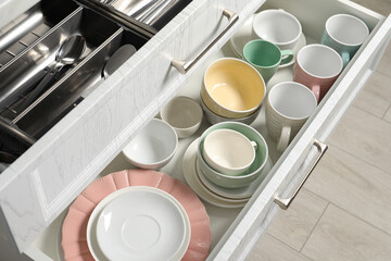 Wall Mural - Ceramic dishware and cutlery in drawers indoors