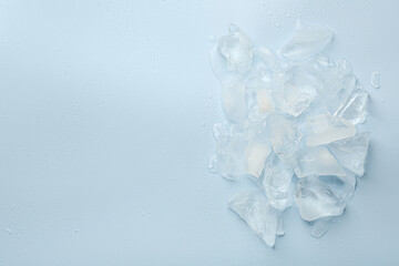 Wall Mural - Pieces of crushed ice on light blue background, top view. Space for text