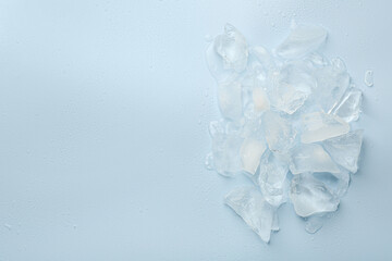 Canvas Print - Pieces of crushed ice on light blue background, top view. Space for text