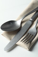 Wall Mural - Stylish cutlery set and napkin on white table, closeup