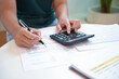 © Charlie's - Businesswoman Accountant analyzing investment charts Invoice and pressing calculator buttons over documents. Accounting Bookkeeper Clerk Bank Advisor And Auditor Concept.