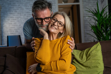 Handsome old man and attractive old woman are enjoying spending time together. Love lives forever! Senior couple at home. The lovely couple spends time together smiling