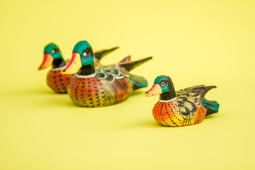 Handmade Wooden Duck Family on a Yellow Background