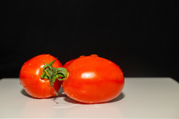 Washed red tomatoes on a white background. Black background.