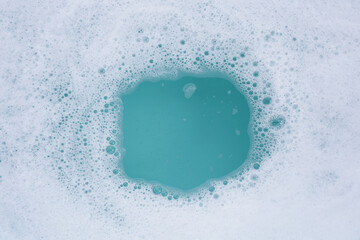 Wall Mural - Detergent foam bubble on water. Blue background, Soap sud