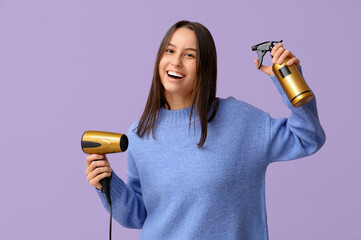 Sticker - Happy young woman with hair dryer and spray on lilac background