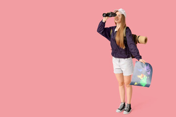 Poster - Young woman with binoculars and map on pink background. Travel concept