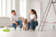 © Pixel-Shot - Happy young couple with ladder and cute dog during repair of their new house