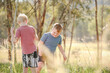 © Austockphoto - Brothers playing together swinging on rope in the Australian bush
