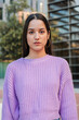 © Jose Calsina - Vertical A Portrait of a Determined Young Latina female Student Standing Alone, Gazing Forward with a Reflective Expression, Radiating Confidence and Self-Assurance. Woman looking serious at camera
