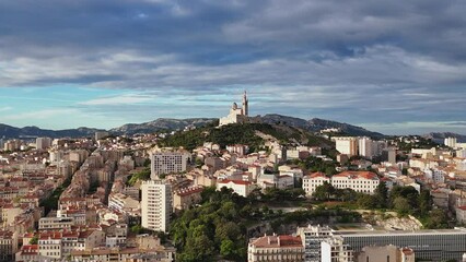 Wall Mural - Aerial view of the city of Marseille, France at sunrise. Basilique Notre-Dame de la Garde on top of hill - landscape panorama of Europe drone view