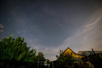 the starry sky on a summer night over a country house