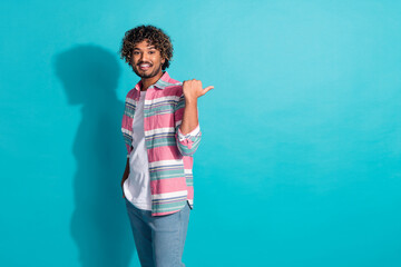 Wall Mural - Photo of satisfied nice cheerful man wear trendy striped clothes demonstrate empty space isolated on cyan color background
