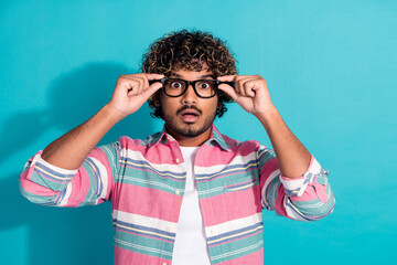 Wall Mural - Photo of impressed shocked man wear trendy striped clothes hold glasses isolated on cyan color background