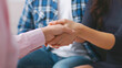 © Prostock-studio - A close-up photo of two people shaking hands, likely during a group meeting or therapy session. The man and woman are wearing casual clothing and are focused on their handshake, cropped