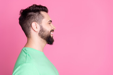 Wall Mural - Side profile photo of nice guy with stylish beard dressed green t-shirt look at barbershop empty space isolated on pink color background