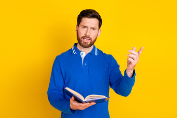 Photo portrait of handsome young guy read book teach lecture dressed stylish blue garment isolated on yellow color background