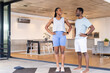 © Wavebreak Media - Young Black couple exercising together at home, standing on yoga mats and smiling