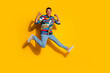 © deagreez - Full length photo of nice young male running winning dressed stylish colorful garment isolated on yellow color background
