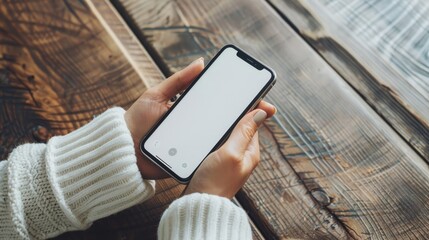 Hand holding and using smartphone with white blank on screen.
