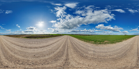 Wall Mural - blue sky hdri 360 panorama with awesome clouds on gravel road among fields in spring day in equirect