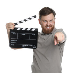 Poster - Making movie. Smiling man with clapperboard pointing at camera on white background