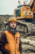 © Erik González - A man in a yellow hard hat stands in front of a large construction vehicle