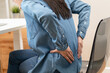© Pormezz - Close-up woman massaging her lower back has back pain because of sitting posture during work in office.