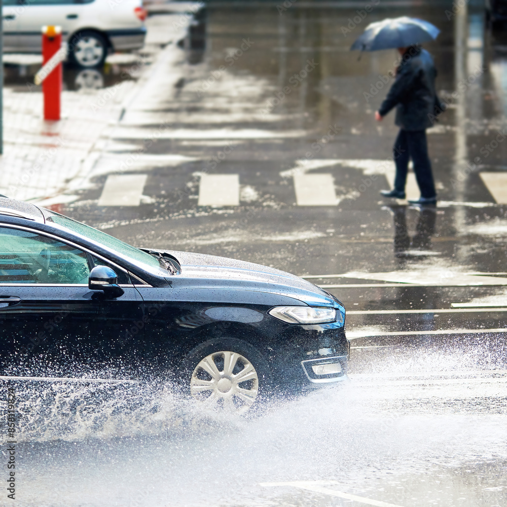 Car driving through puddle, fast driving on wet road during rain ...