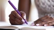 © 2rogan - Women writing with a purple pen on a blank notebook