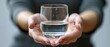 © STOCKYE STUDIO - A clear glass of water held in hand, showcasing clean, transparent liquid. Closeup highlights the health benefits of this refreshing beverage