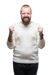 Sticker - Young caucasian hipster man wearing winter sweater over isolated background excited for success with arms raised celebrating victory smiling. Winner concept.