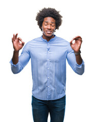 Canvas Print - Afro american man over isolated background relax and smiling with eyes closed doing meditation gesture with fingers. Yoga concept.