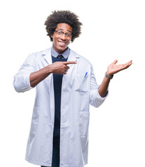 Wall Mural - Afro american doctor scientist man over isolated background amazed and smiling to the camera while presenting with hand and pointing with finger.