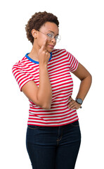 Sticker - Beautiful young african american woman wearing glasses over isolated background Pointing to the eye watching you gesture, suspicious expression